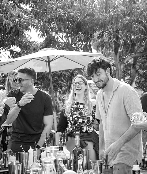 Three colleagues laughing at an outdoor bar