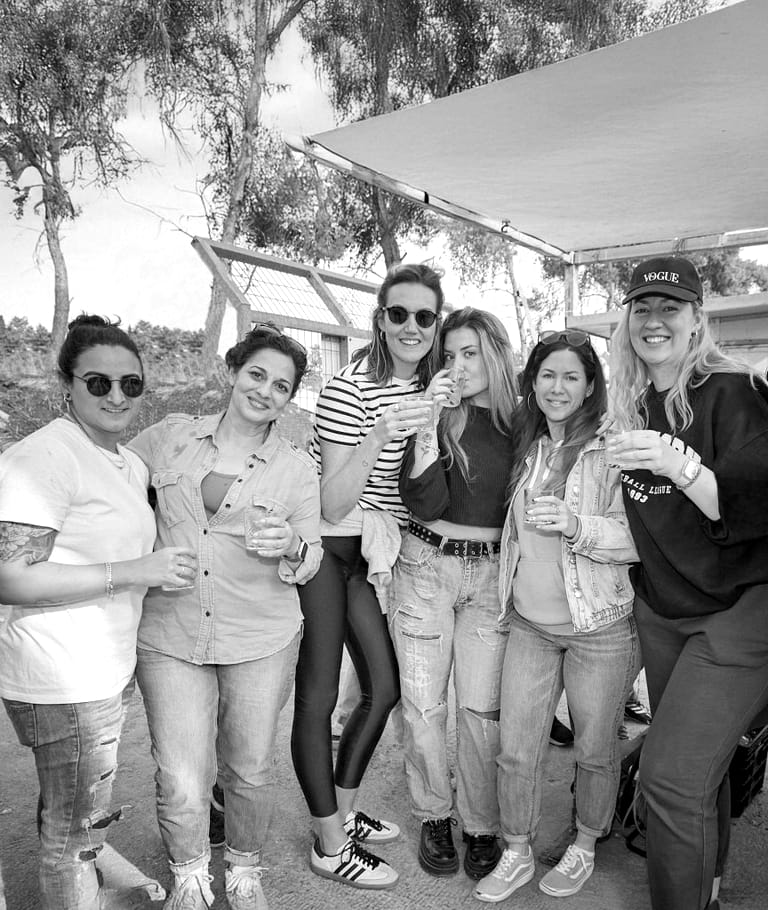 A group of women from the team toasting under a canopy