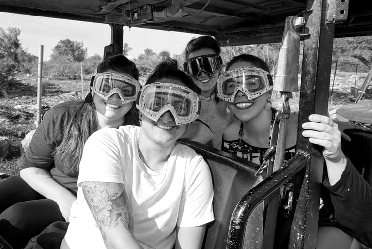 Four colleagues in goggles before an off-road drive