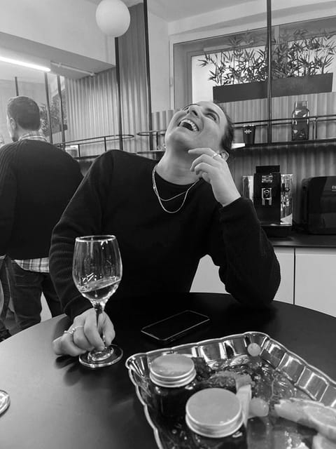 A colleague laughing mid-conversation with a glass in hand