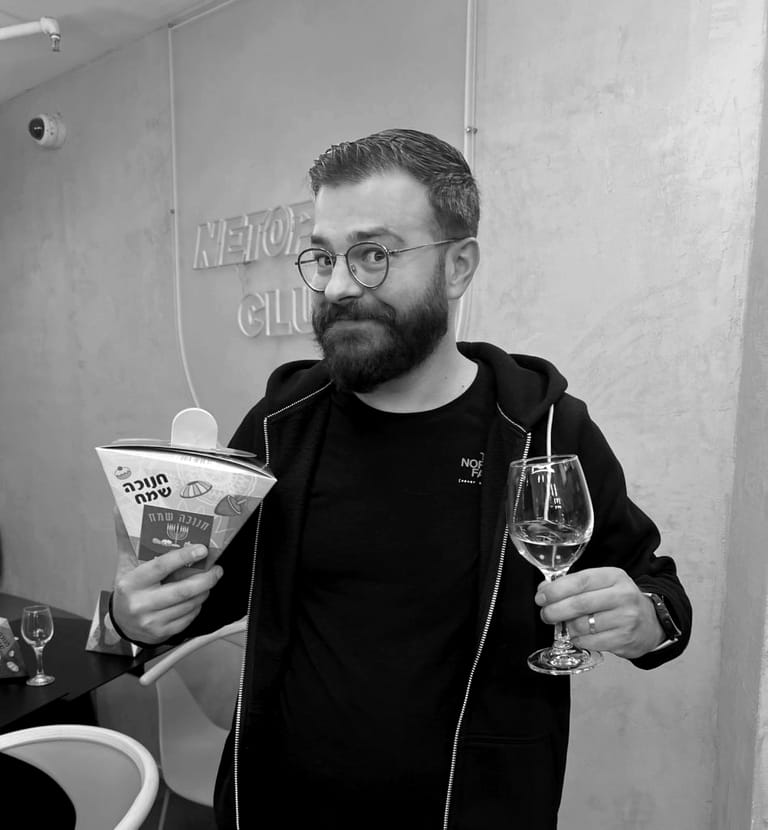 A bearded colleague holding a drink at a team evening