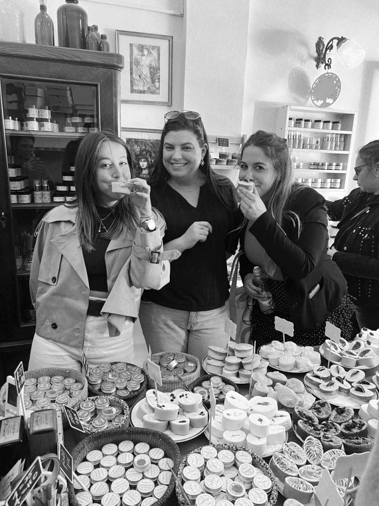 Three colleagues tasting something at the counter of a small shop
